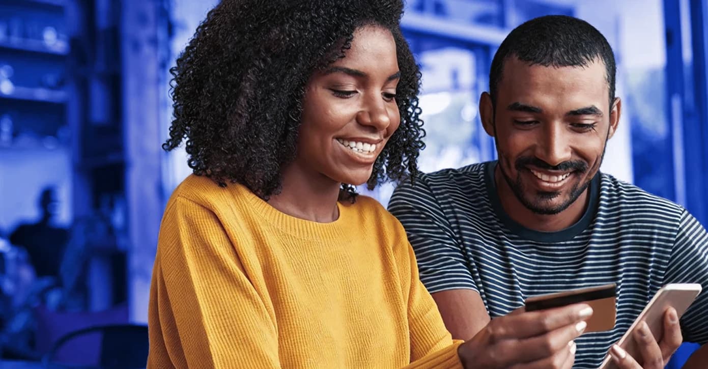 Casal a fazer compras online com cartão e telemóvel